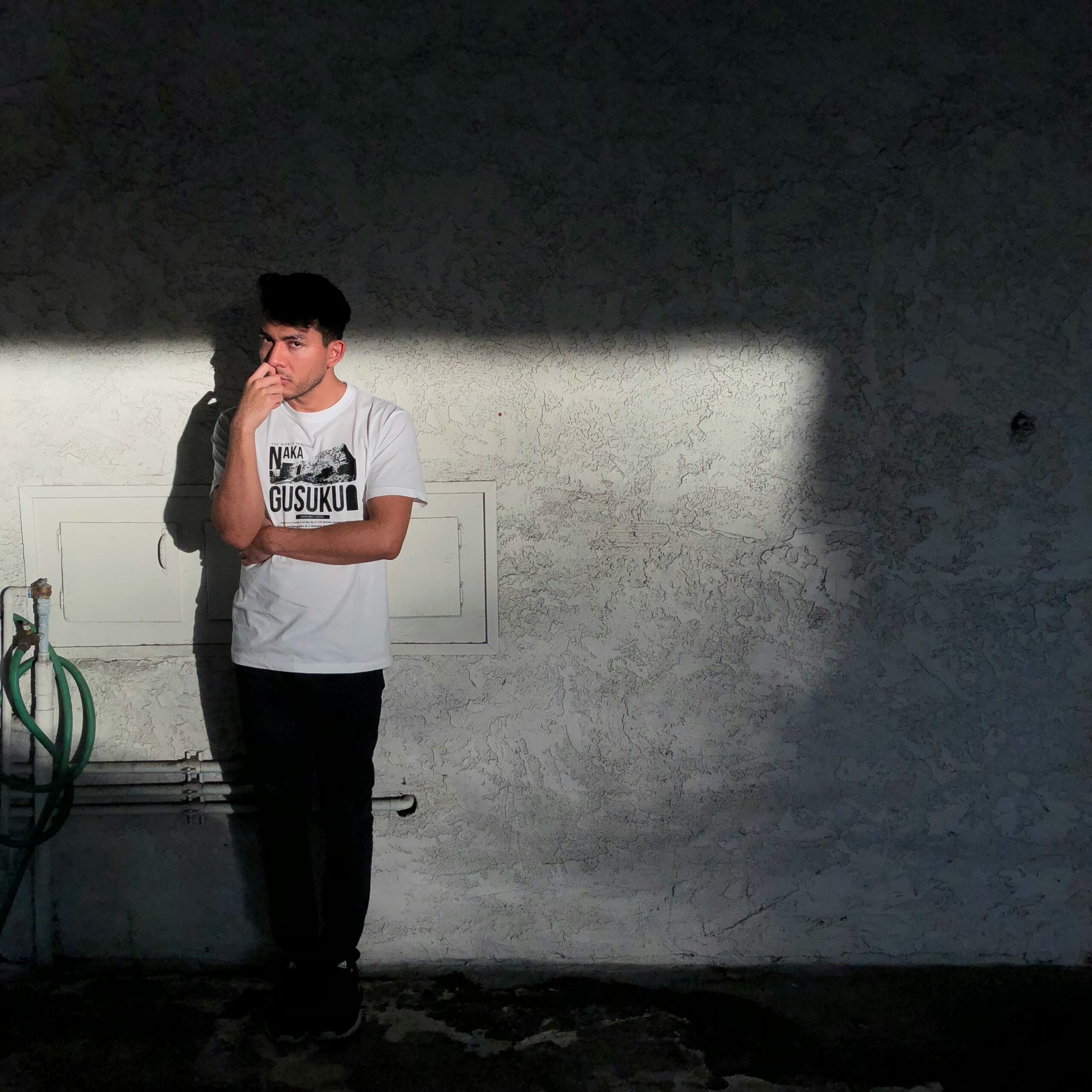 A man standing alone in the darkness of a room