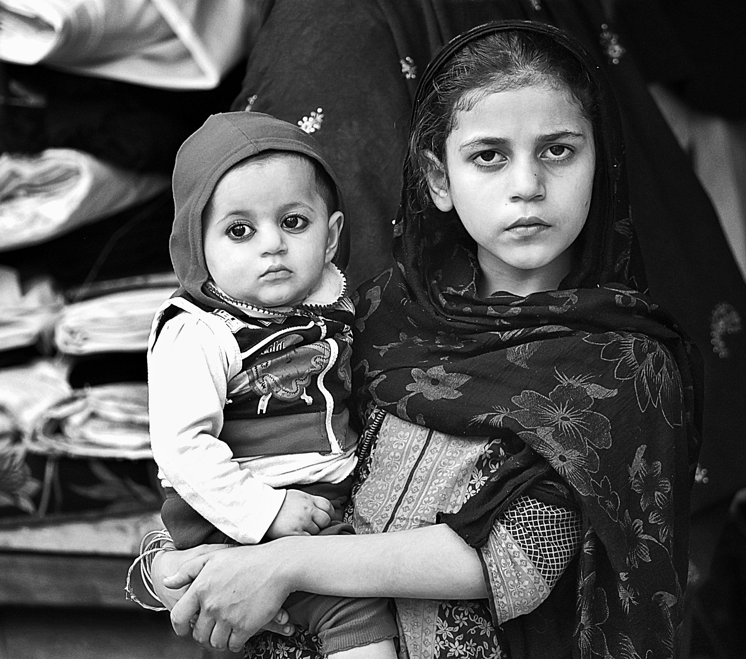 A pakistani girl holding a little girl, perfect theme as per the article of gender inequality